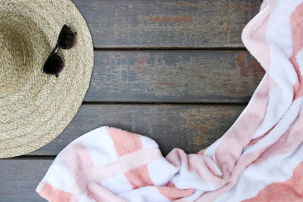 Op vista de toalha e chapéu de palha no fundo de madeira — Fotografia de Stock