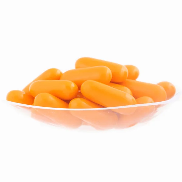 Πορτοκαλί σωρός από χάπια με το πλαστικό κουτάλι απομονωμένη στο φόντο — Φωτογραφία Αρχείου