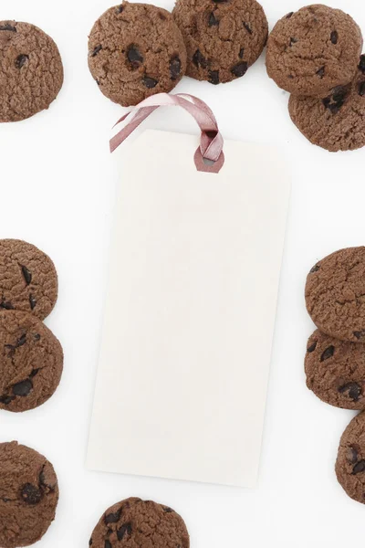 Vista desde arriba en etiqueta de papel rodeada de galletas de chocolate — Foto de Stock