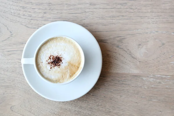 Cup of cappuccino with foam on the wooden table — Stock Photo, Image