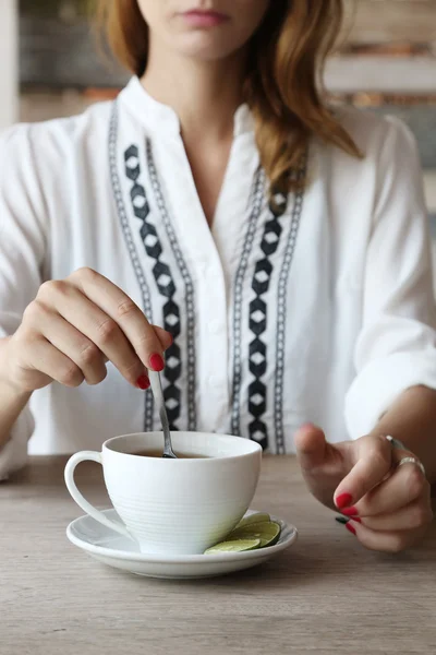 Hora del té. Chica en la cafetería añadiendo azúcar en la taza de té —  Fotos de Stock