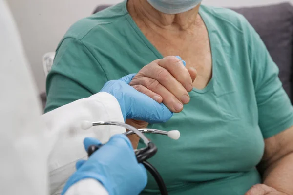 Portrait of elderly caucasian woman wearing protective medical mask. Care for the elderly people during corona virus outbreak, a helping hand, home care concept.