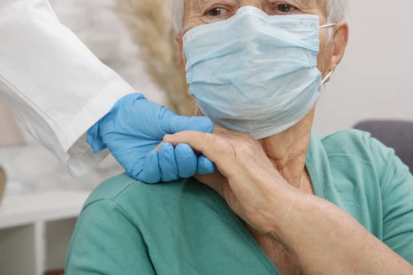 Portrait of elderly caucasian woman wearing protective medical mask. Care for the elderly people during corona virus outbreak, a helping hand, home care concept.