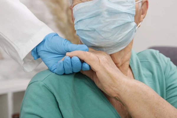 Portrait of elderly caucasian woman wearing protective medical mask. Care for the elderly people during corona virus outbreak, a helping hand, home care concept.