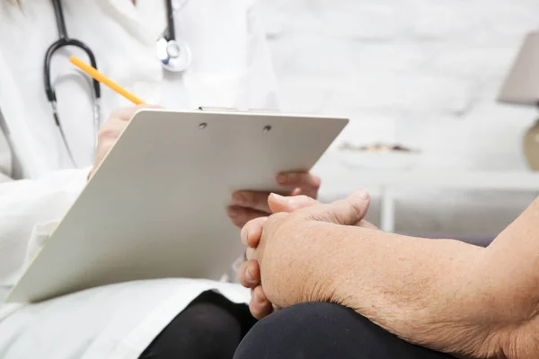 Senior patient having consultation with doctor in the home care or geriatric center