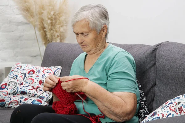 Femme Âgée Assise Sur Canapé Tricotant Avec Laine Rouge Article — Photo