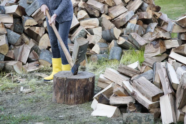 黄色のゴムブーツの女性斧で森を切り刻む 農場の秋のためのホームステッド家事 — ストック写真