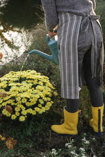 Νεαρός Κηπουρός Κίτρινες Λαστιχένιες Μπότες Ποτίζει Λουλούδια Στον Κήπο — Φωτογραφία Αρχείου
