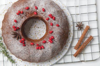 Kırmızı böğürtlenler ve beyaz arka planda köknar dallarıyla süslenmiş şenlikli kek..