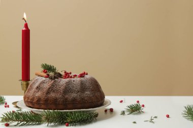 Kırmızı böğürtlenli, arka planda süslü bir kek..