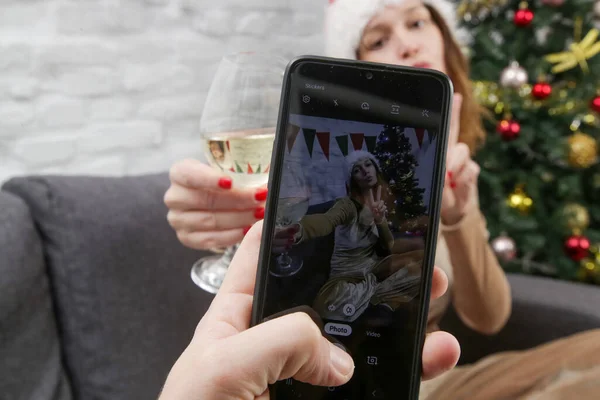 Pomponlány Fiatal Mikulás Kalapban Pózol Telefon Kamera Előtt Egy Pohár — Stock Fotó