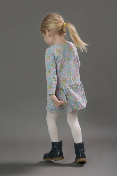 ファッションスタジオポートレートの可愛いです3歳ブロンド女の子で花パターンドレス上の灰色の背景 — ストック写真