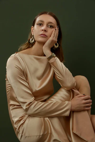 ファッションスタジオショットの女性でベージュシルクサテンドレス — ストック写真