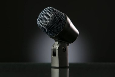 Siyah arkaplanda gradyanı olan bir mikrofon.