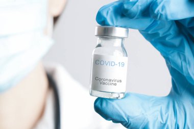 Bilim adamı ya da tıp çalışanı Corona virüs aşısı şişesini elinde tutuyor. Aşı, aşı, Covid 19 enfeksiyonunu tedavi etmek için tedavi. Sağlık ve Tıp Konsepti.