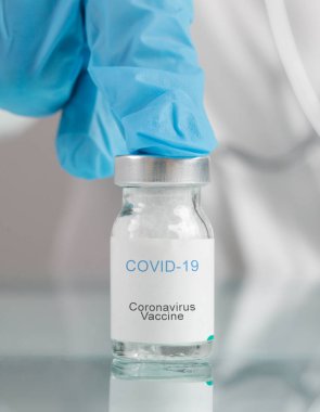Bilim adamı ya da tıp çalışanı Corona virüs aşısı şişesini elinde tutuyor. Aşı, aşı, Covid 19 enfeksiyonunu tedavi etmek için tedavi. Sağlık ve Tıp Konsepti.
