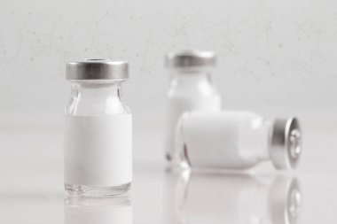 Aşı görüntüsünü kapat ya da beyaz etiketli enjeksiyon şişelerini kapat. Şişe maketi. Bilim, aşı, aşı, aşı, sağlık ve tıbbi konsept. 