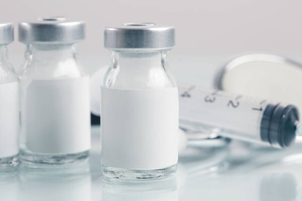 Close up image of vaccine or injection bottles with blank white label.  Vial bottle mockup. Science, vaccination, immunization, health care and medical concept.  