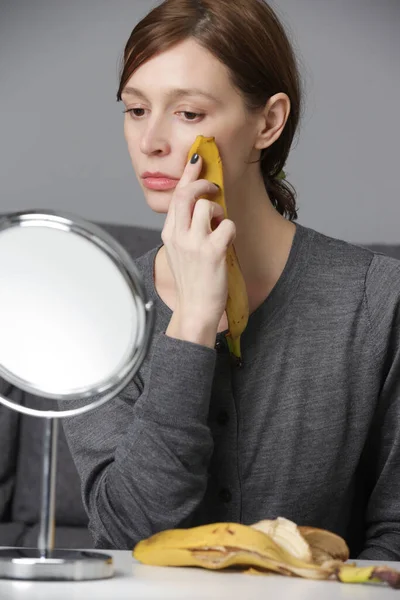 Kvinnan Gnider Bananskal Ansiktet För Att Ljusa Upp Och Återfukta — Stockfoto