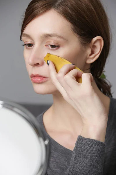 Mulher Esfregando Casca Banana Seu Rosto Para Iluminar Hidratar Pele — Fotografia de Stock