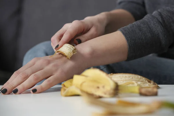 女性はバナナの皮を手にこすりつけて肌を水和物にする 廃棄物ゼロ 天然スキンケアコンセプト — ストック写真