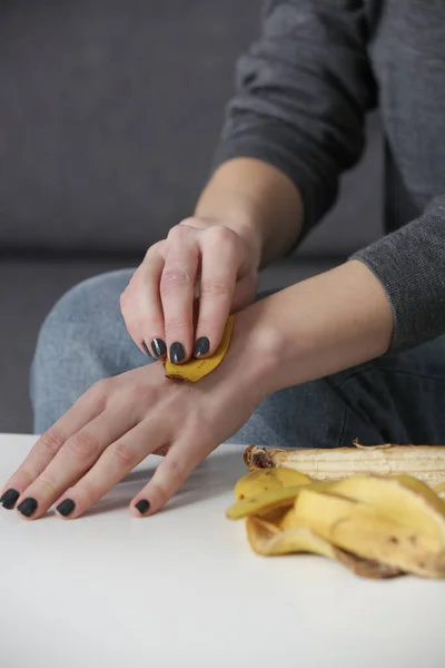 女性はバナナの皮を手にこすりつけて肌を水和物にする 廃棄物ゼロ 天然スキンケアコンセプト — ストック写真