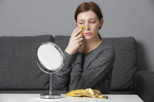 女性は顔にバナナの皮をこすり 肌を明るくし 水和物を減らします 廃棄物ゼロ 天然スキンケアコンセプト — ストック写真