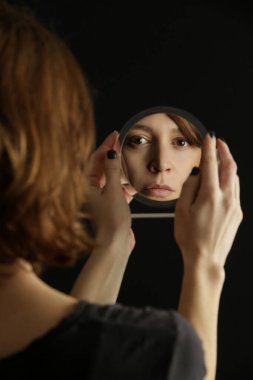 Mirror reflection of a woman's face, studio shot clipart