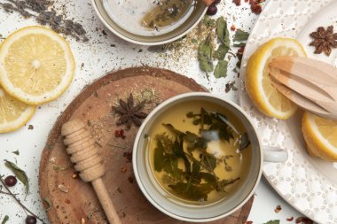 Bitki çayı, en iyi manzara. Kuru otlar, limon dilimleri ve beyaz çay fincanları. Toptan bitkiler, sıfır atık ve çevre dostu yaşam tarzı, bitkisel tıp konsepti.
