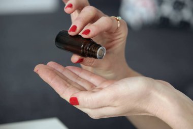 Bir şişe gerekli yağı tutan kadın elleri.