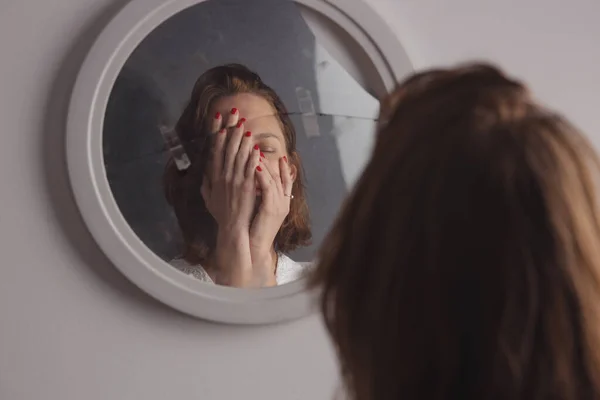 Reflection of a woman\'s face in broken mirror. Depression, anxiety, phobia, suicide and mental health concept.