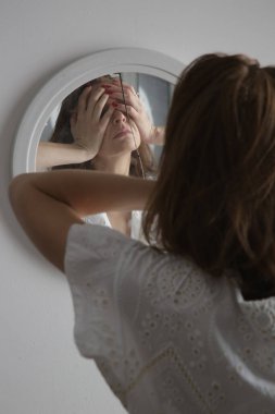 Kırık aynada bir kadının yüzünün yansıması. Depresyon, anksiyete, fobi, intihar ve zihinsel sağlık kavramı.