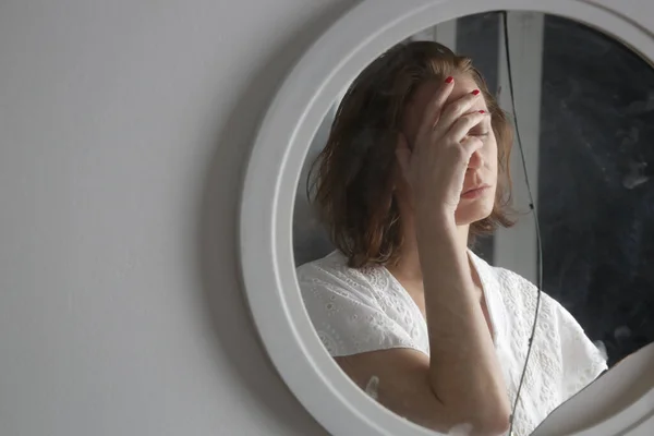 Reflection of a woman\'s face in broken mirror. Depression, anxiety, phobia, suicide and mental health concept.