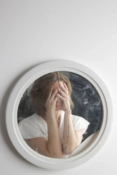 Reflection of a woman's face in broken mirror. Depression, anxiety, phobia, suicide and mental health concept.