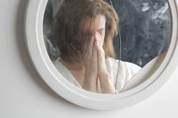 Reflection of a woman\'s face in broken mirror. Depression, anxiety, phobia, suicide and mental health concept.
