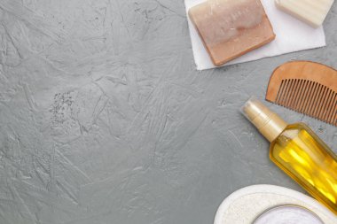 Various toiletries on textured gray background, top view