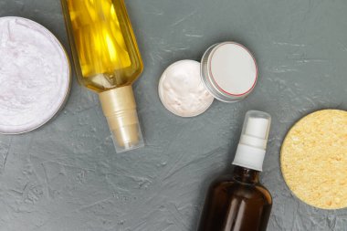 Various toiletries on textured gray background, top view