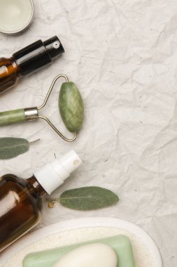 Doğal organik cilt bakım ürünü. Ev spa ve kendine bakım konsepti. Yüz serumu, yeşim rulo ve kopyalama alanı olan sabun çubuğu..
