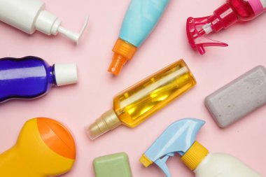 Parlak pembe arka planda renkli kozmetik ürünleri, üst görünüm