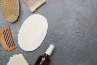 Various toiletries on textured gray background, top view
