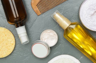 Various toiletries on textured gray background, top view