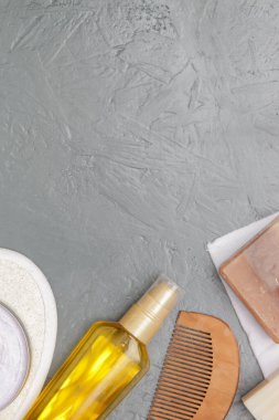 Various toiletries on textured gray background, top view