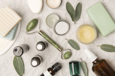 Doğal organik cilt bakım ürünleri. Ev spa 'sı ve kişisel bakım ürünü üst görünümü. Yüz serumları, temel malzemeler yağlar, kremler, yeşim silindirler ve kopyalama alanı olan sabunlar.