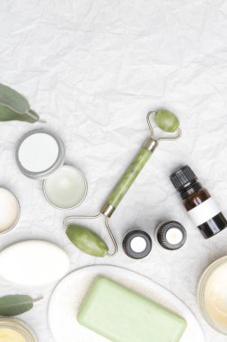 Doğal organik cilt bakım ürünleri. Ev spa 'sı ve kişisel bakım ürünü üst görünümü. Yüz serumları, temel malzemeler yağlar, kremler, yeşim silindirler ve kopyalama alanı olan sabunlar.