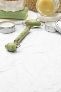  Doğal organik cilt bakım ürünü. Ev spa ve kendine bakım konsepti. Yüz serumu, yeşim rulo ve kopyalama alanı olan sabun çubuğu..