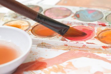 Bir boya fırçasının görüntüsünü kapat. Yaratıcı hobi ya da sanat terapisi kavramı.