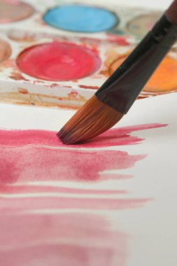 Bir boya fırçasının görüntüsünü kapat. Yaratıcı hobi ya da sanat terapisi kavramı.
