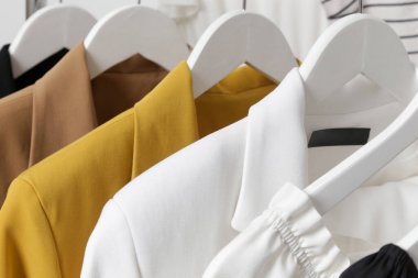 Kadın kıyafetleri. Moda atölyesinde giysi askısı ve şık kıyafetler. Yazlık gardırop stantta. 