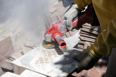 Yeniden kullanım için eski fayanslardan havan ve yapıştırıcı kaldırılıyor. 