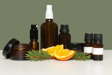 Yeşil arka planda çeşitli kahverengi cam kozmetik şişeleri